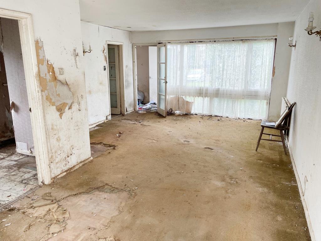 Lot: 127 - HOUSE IN NEED OF REFURBISHMENT AND REPAIR - view of living room from patio doors
